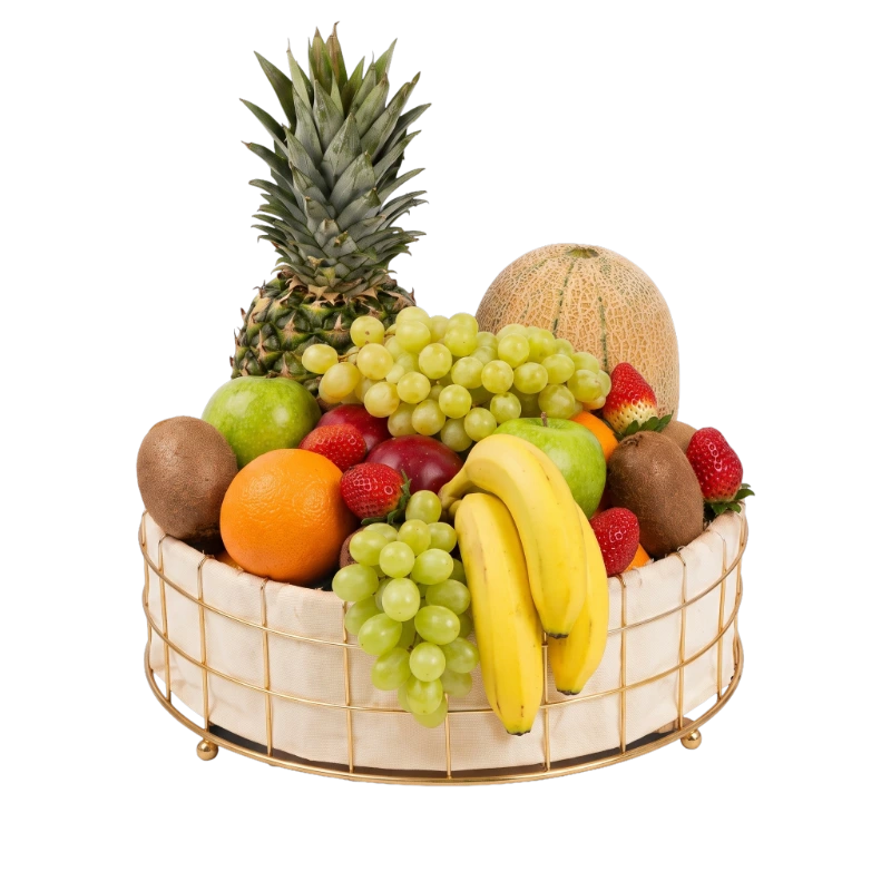 The Harvest Luxe Fruit Basket featuring fresh pineapple, grapes, apples, bananas, oranges, strawberries, kiwi fruit, melon, and seasonal fruit in a reusable gold wire basket by Gifts & Co.